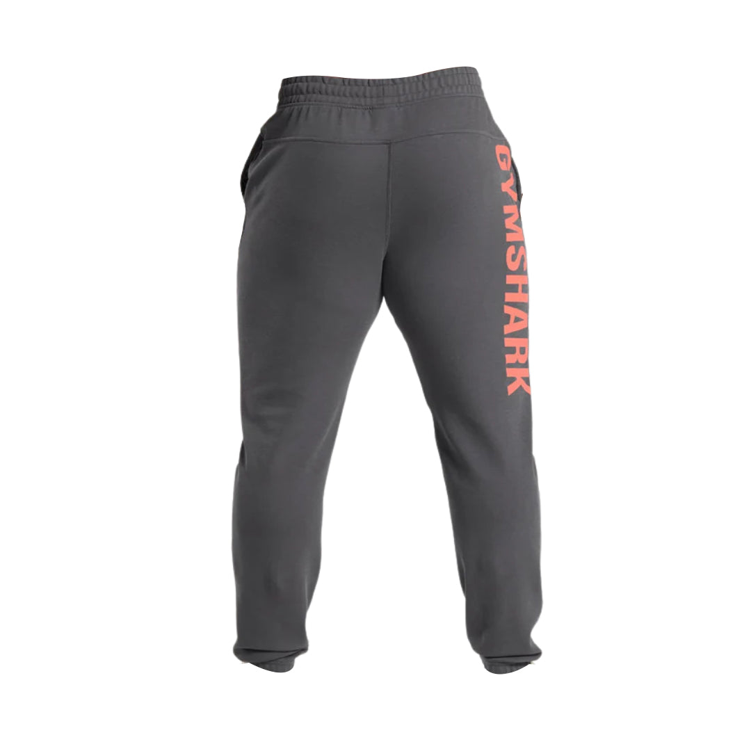 Gray gym pants featuring the "GYMSHARK" logo in coral on the left leg, designed for comfort and performance.