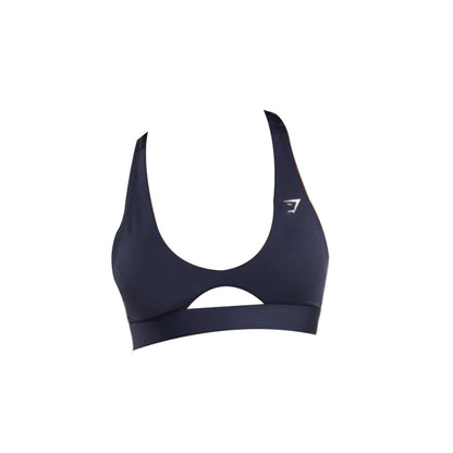 Navy blue Gymshark sports bra with a rounded peek-a-boo cut out, and the Gymshark logo, isolated on a white background.