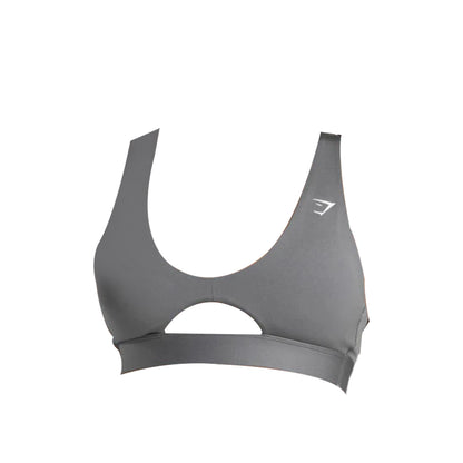 Close-up of a gray Gymshark sports bra featuring a high neckline and a keyhole cutout just above the band, with the Gymshark logo visible on the left side.