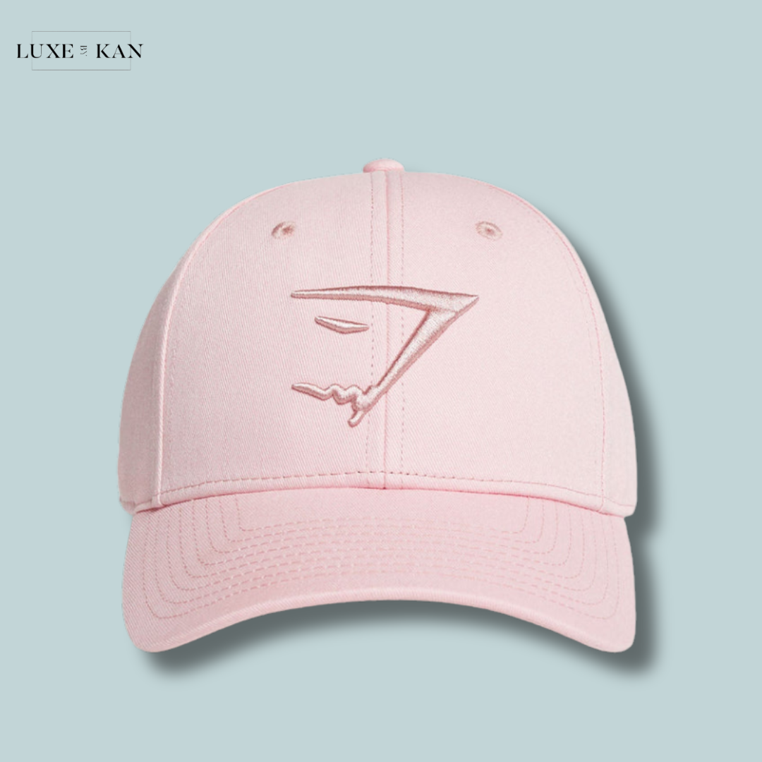 A pale pink sharkhead cap featuring an embossed sleek logo design.