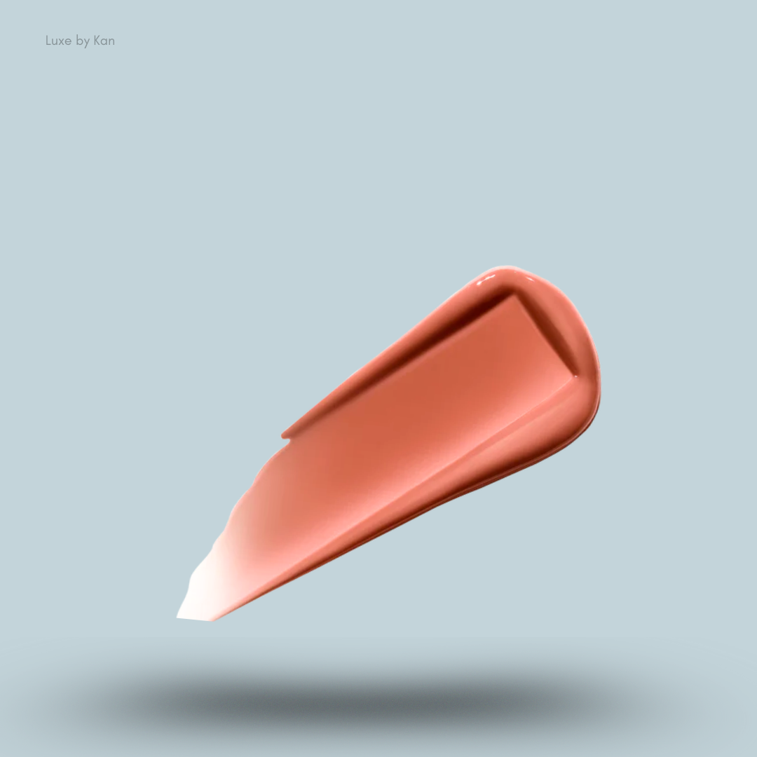 A glossy swatch of the rosy-coral shade 'Sense' of the Hourglass Phantom Volumizing Glossy Lip Balm.