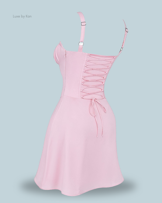 A stylish pink carlotta corset mini dress with adjustable straps and a lace-up back, featuring a soft, flared skirt. Perfect for any occasion.