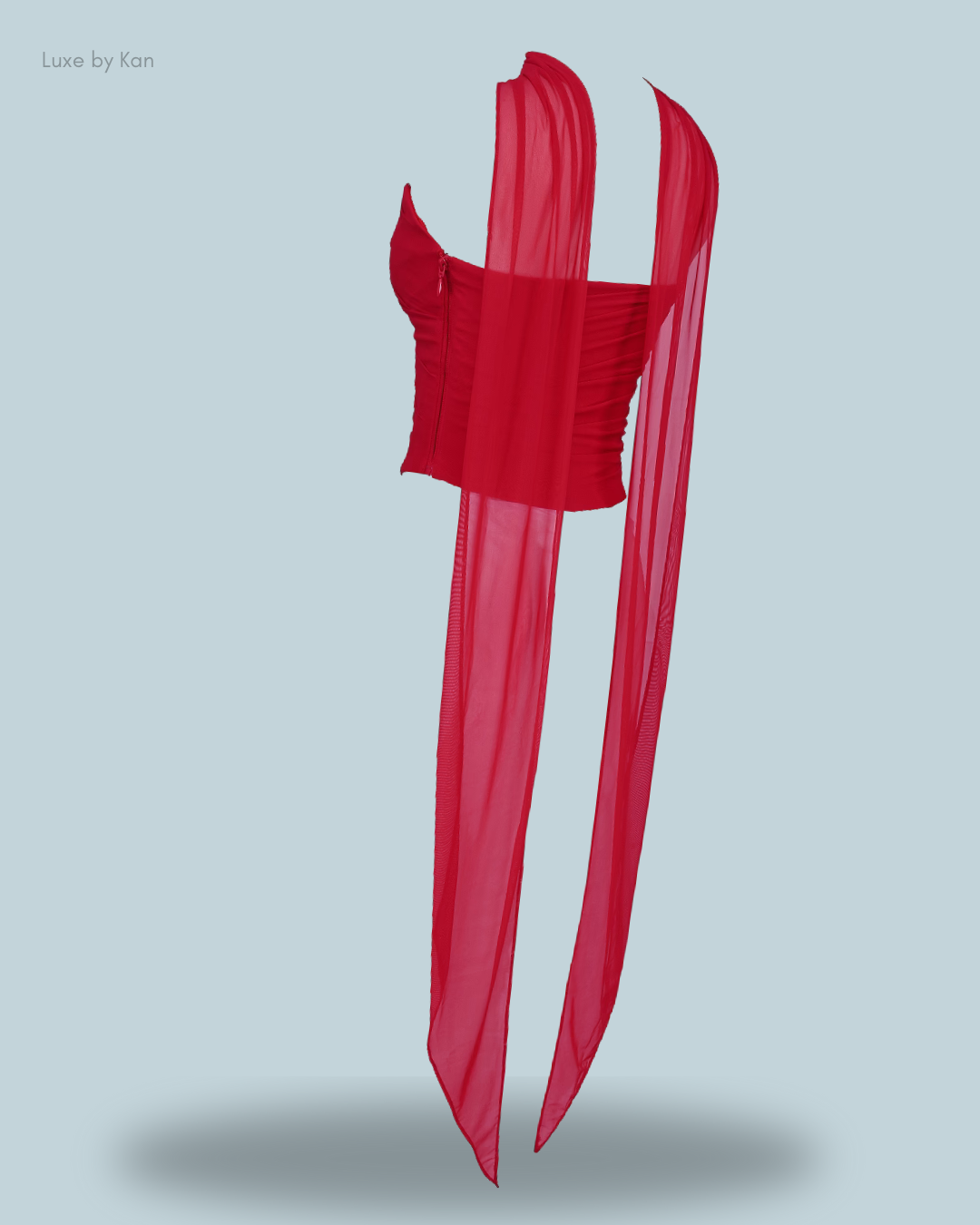 A stylish red Hallie strapless corset top with a detachable neck scarf and sheer, flowing drapes. An elegant and eye-catching design.