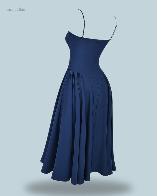 A stylish navy blue House of CB Samaria corset midi dress featuring a structured bodice and a softly flowing skirt for an elegant silhouette.