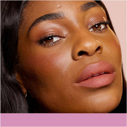 A close-up image featuring long, dark hair on the left, fading into a warm gradient background with a soft pink base.