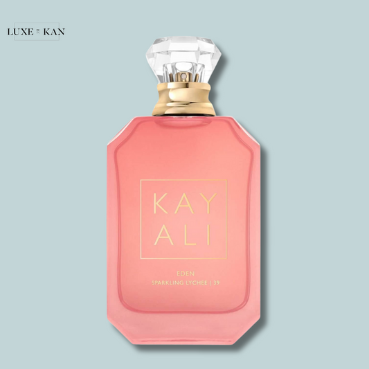A pink perfume bottle from Huda beauty, labeled "KAYALI EDEN SPARKLING LYCHEE | 39" featuring a diamond-shaped cap.