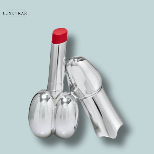 A shiny silver isamaya beauty colour infusion lipstick tube featuring a bright red tip, creatively designed to resemble a pair of buttocks.