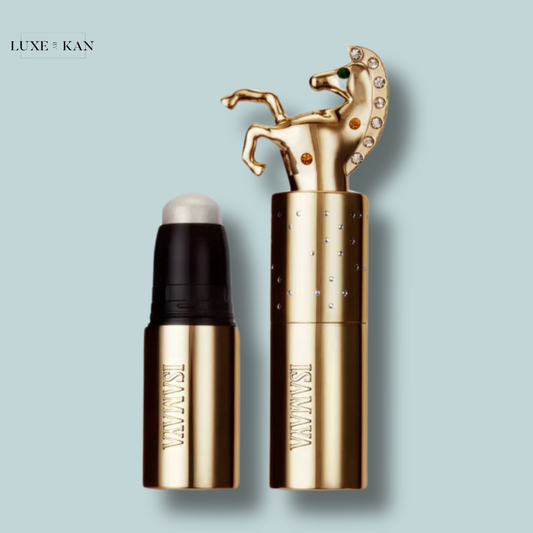 Isamaya beauty dazzle up highlighter in sun chaser featuring a horse-shaped cap adorned with rhinestones and an accompanying rollerball applicator.