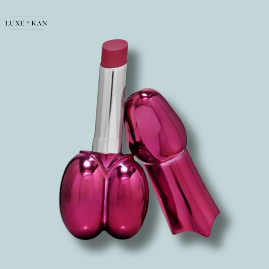 The Isamaya Beauty Sheer Lipstick Balm in Flamingo is shaped like stylized buttocks, featuring a silver cap and a creamy pink lipstick bullet.