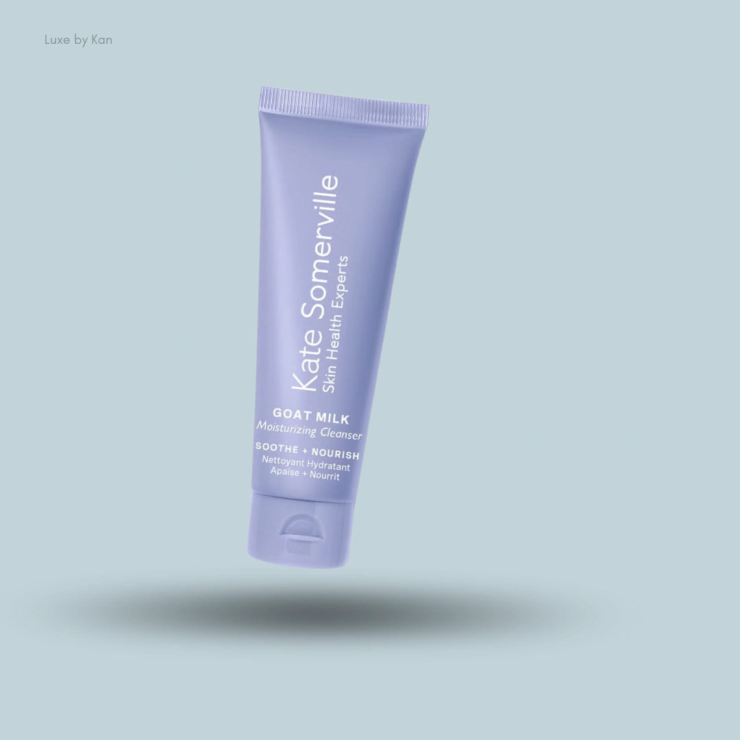A purple tube of Kate Somerville Goat Milk Moisturizing Cleanser floats over a light blue background with a soft shadow.