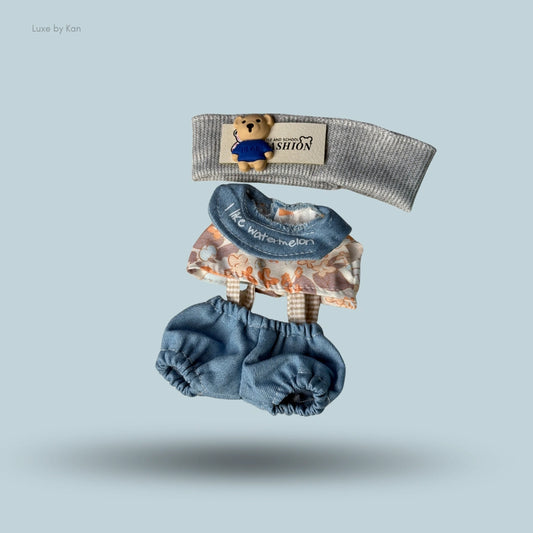 Labubu doll's grey headband with bear patch, brown floral top with "I like watermelon", and denim shorts.