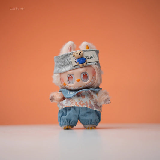 Labubu doll in teddy picnic casual outfit set, featuring a gray beanie with a bear appliqué, floral shirt, and denim pants.