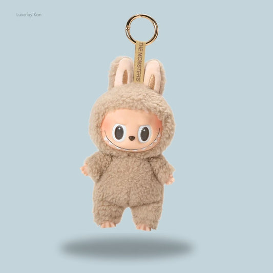 A cute Labubu Tasty Macarons Toffee plush keychain featuring bunny ears, a mischievous grin, and a playful design hanging from a keyring.