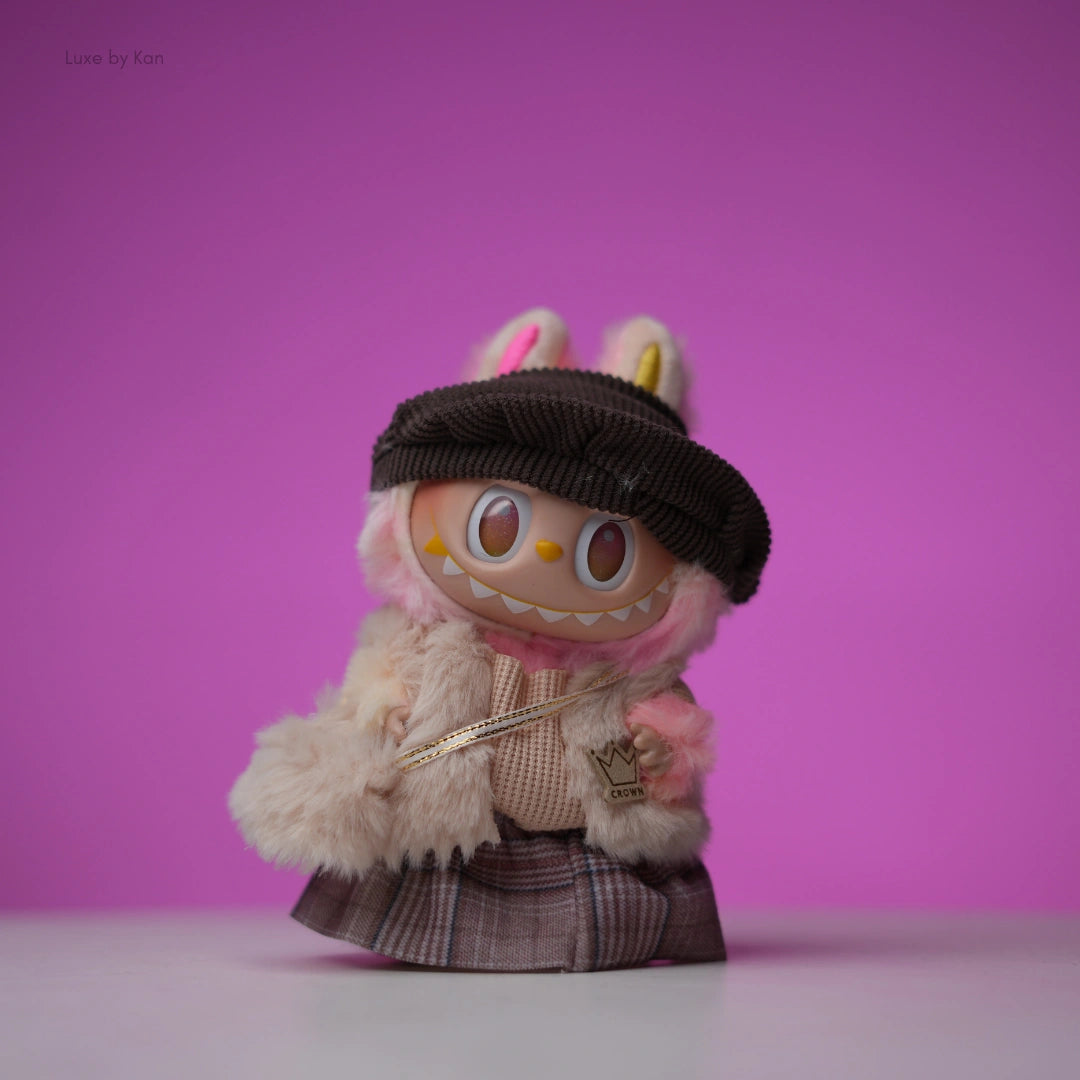 Labubu collectible doll outfitted in a five-piece autumn royale set with pink fur, a brown hat, and plaid skirt.