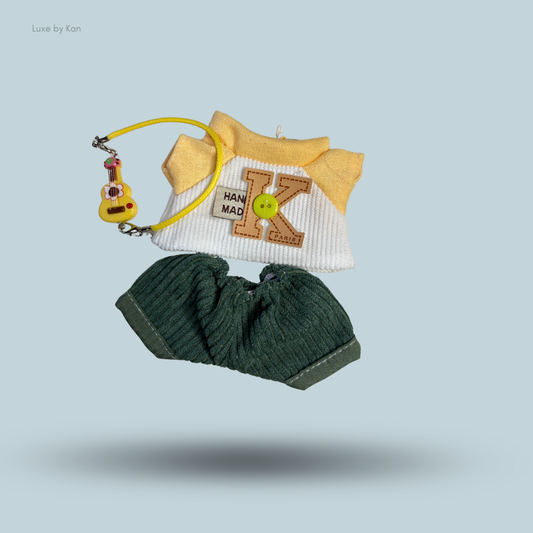 Labubu little explorer dress set, featuring a white and yellow shirt with decorative "K" patch, green corduroy shorts, and yellow guitar accessory.