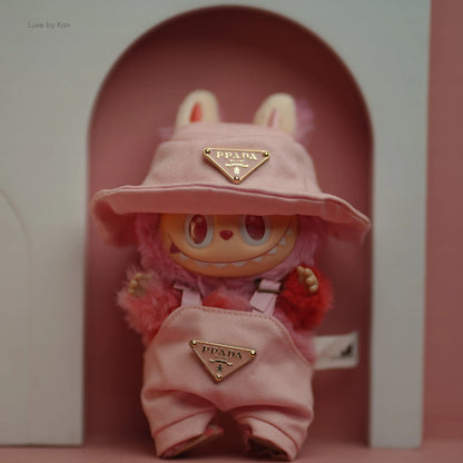 Close-up of Labubu Pink Luxe toy figure wearing pink overalls and a matching bucket hat, both adorned with Prada logos.