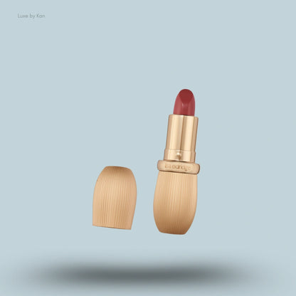 An open tube of Lisa Eldridge Rouge Experience Refillable Lipstick in a berry shade, with its wood-textured cap.