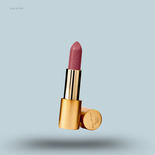 An open tube of Lisa Eldridge True Velvet Lip Colour Lipstick in a rosy-mauve shade with a gold case and cap.