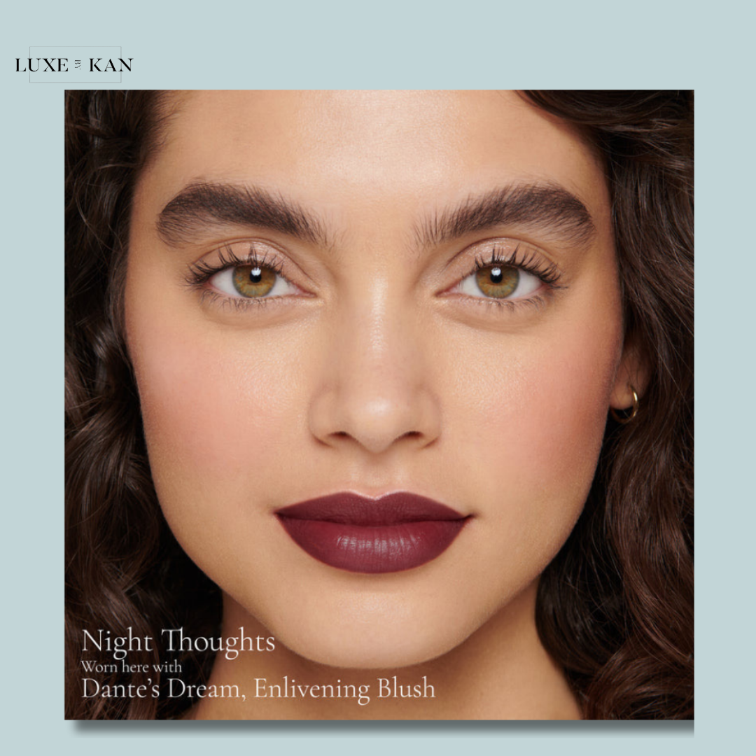 A beauty product display featuring a model's styled hair and skin, showcasing "Dante’s Dream" Enlivening Blush.