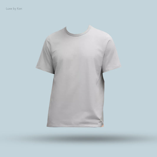 A light gray, short-sleeved t-shirt displayed against a soft blue background, featuring no visible model. Brand: Luxe by Kan.