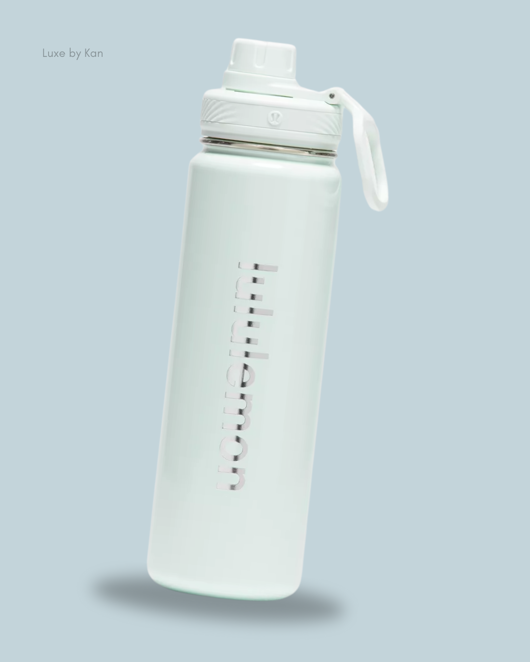 A sleek white water bottle with a flip-top lid, branded "Luxe by Kan," set against a light blue background.