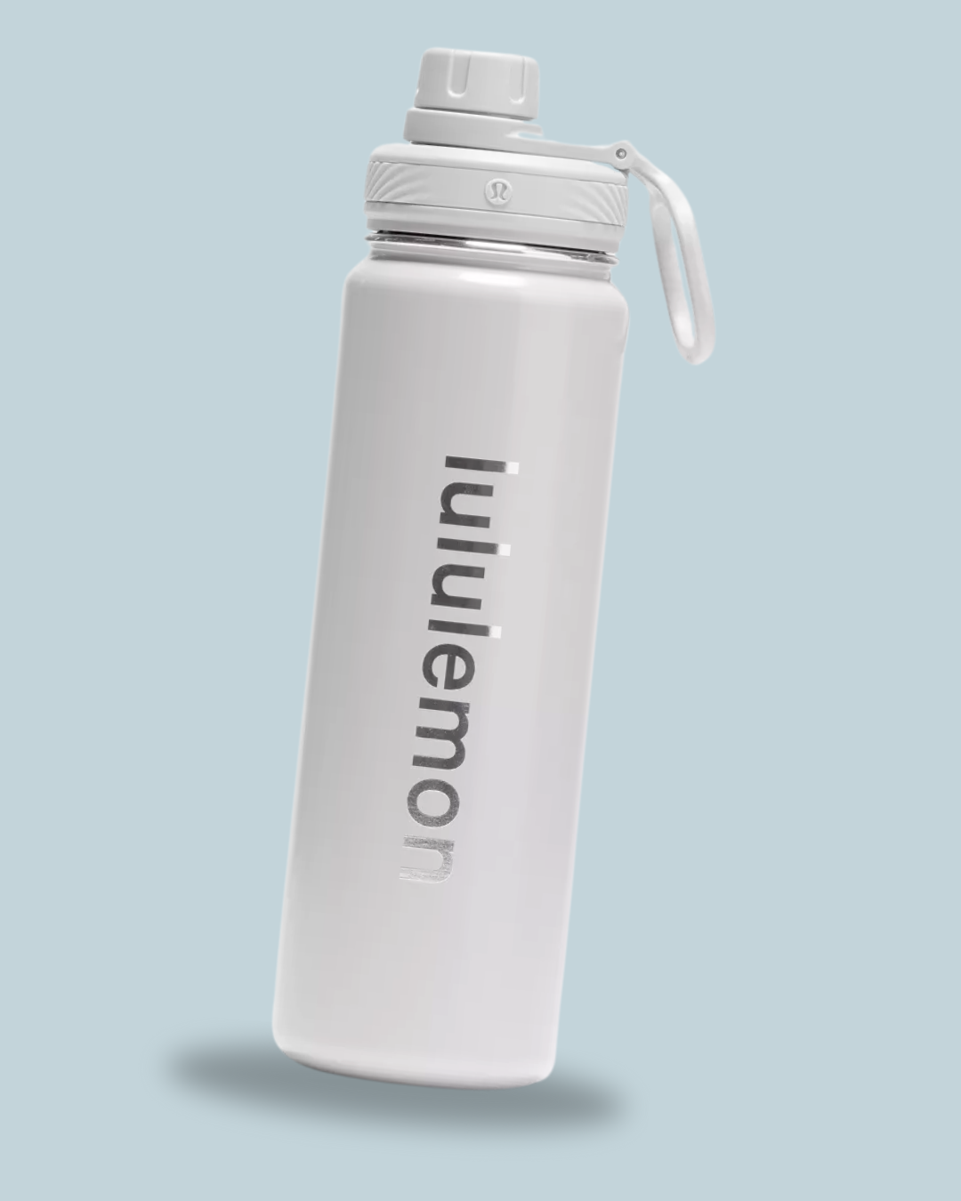 A sleek, white water bottle with "lululemon" printed in silver, featuring a twist cap and a carry loop.