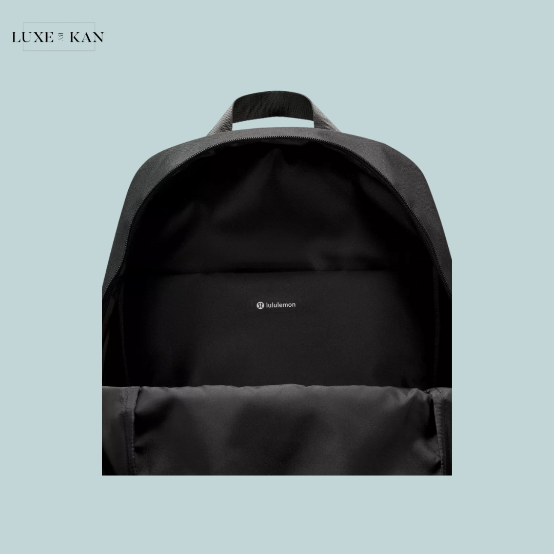 Inside view of a black Lululemon backpack featuring a spacious compartment and a small logo on the back panel.