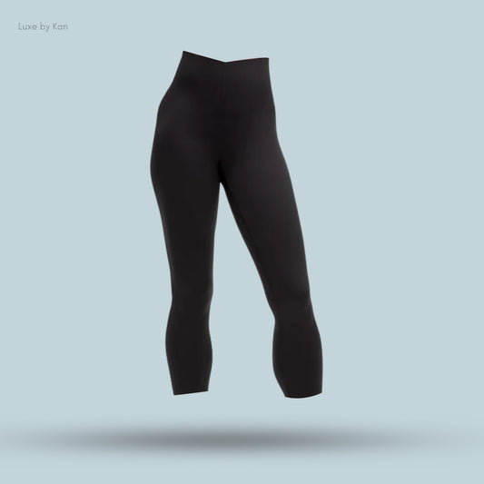 Black high-waisted leggings on a light blue background, showcasing a sleek design and a modern silhouette.