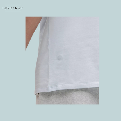 Close-up of a light blue t-shirt side seam featuring a decorative button, paired with gray shorts.