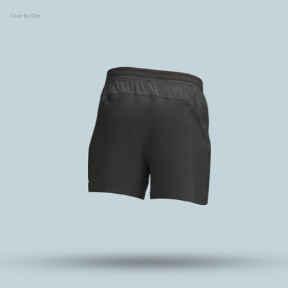 Back view of black athletic shorts displayed against a light blue background, featuring a comfortable elastic waistband.