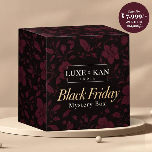 Luxe by Kan Black Friday Mystery Box dark burgundy floral gift box on a beige podium, premium ₹7,999 edition