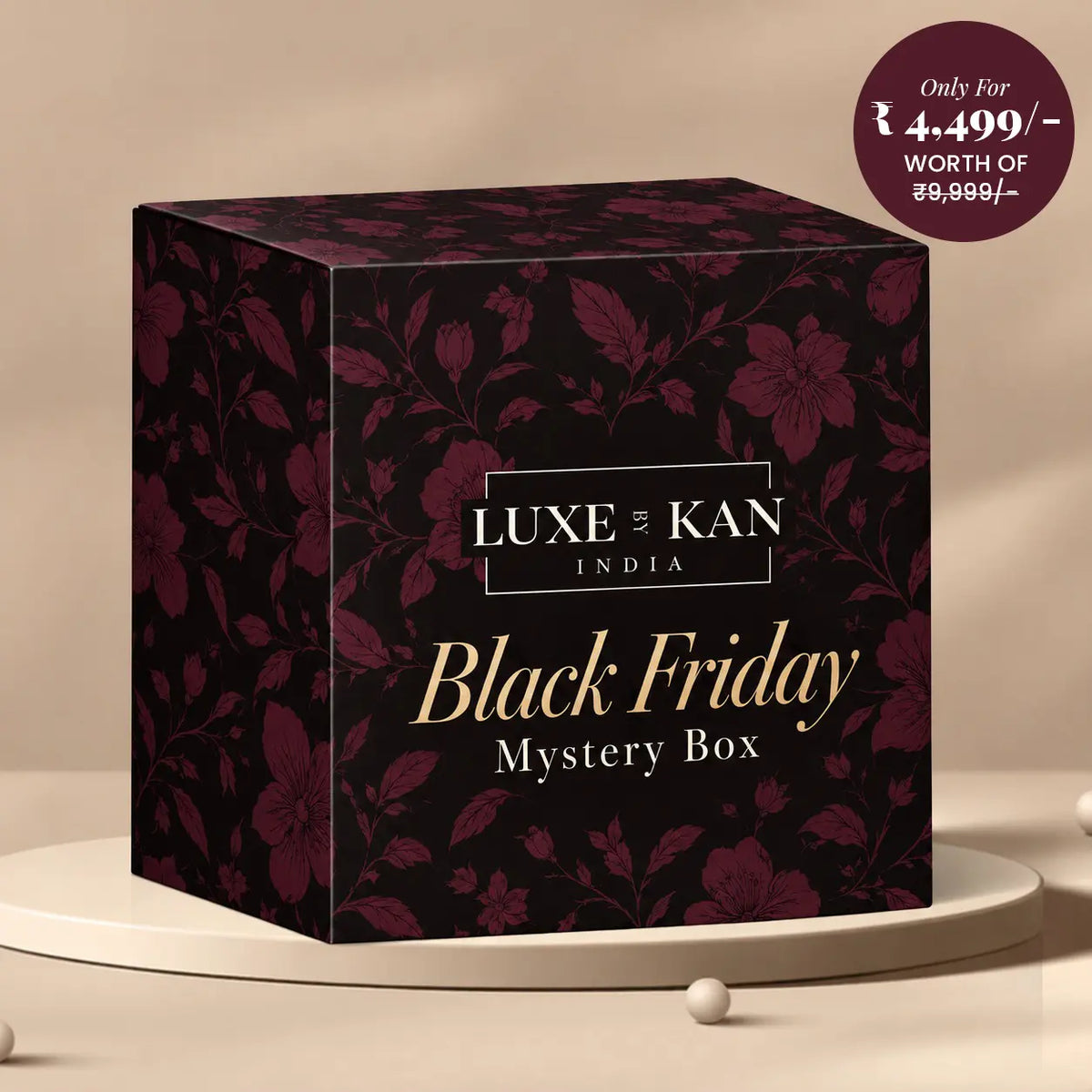 Luxe by Kan Black Friday Mystery Box dark burgundy floral gift box on a beige podium, classic ₹4,499 edition