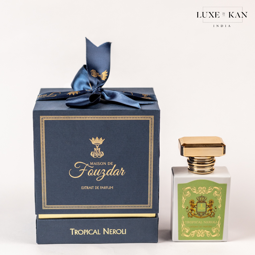 Elegant packaging for "Tropical Neroli" perfume by Maison de Fouzdar, featuring a gold-accented bottle and a navy ribbon-tied box.