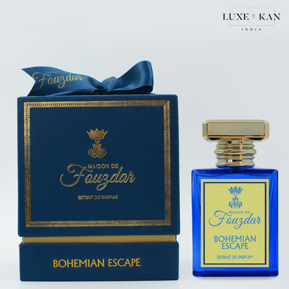 Blue perfume bottle labeled "Bohemian Escape" next to a luxury navy box with gold accents, showcasing Maison de Fouzdar branding.