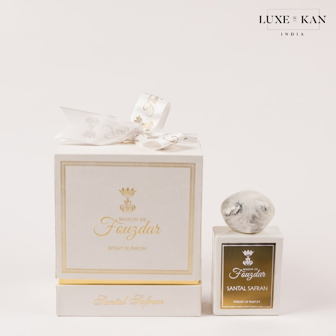 Maison de fouzdar santal safran perfume packaging featuring a white box with a ribbon and a marble-topped bottle.