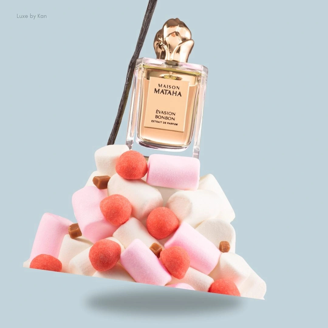Maison Mataha Évasion Bonbon Extrait de Parfum, presented atop a pile of marshmallows, caramel pieces, and a vanilla bean stick.