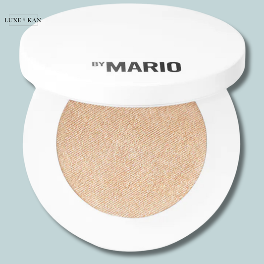 A compact of shimmering golden highlighter by Mario, featuring a white lid with bold text.