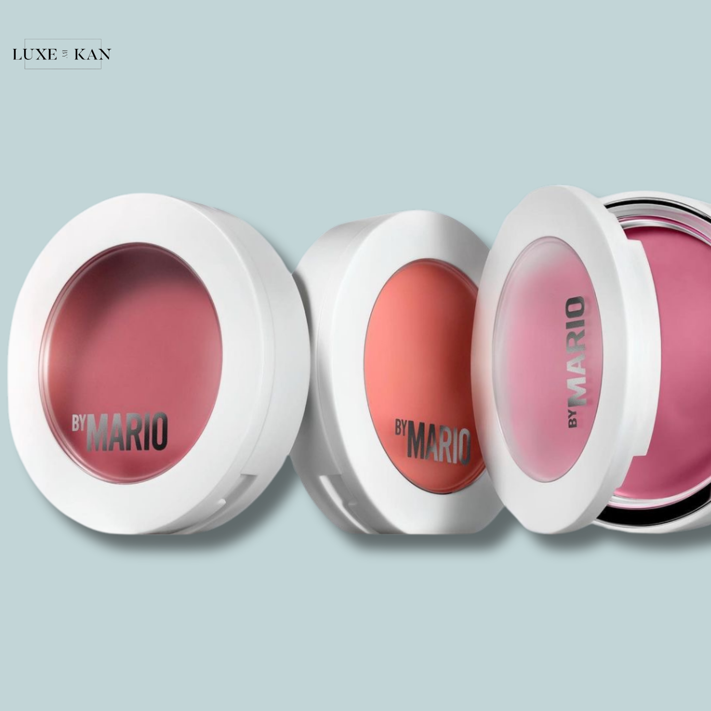 Three blush compacts in varying shades of pink and peach from the "By Mario" collection.