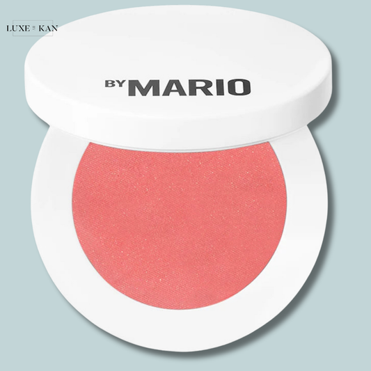 A round compact of blush by Mario in a soft peach shade, featuring a glossy white lid with the logo "by MARIO".