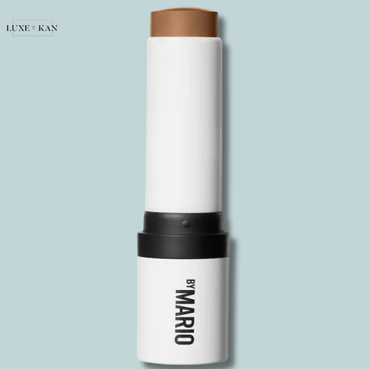 A cream contour stick by Mario, featuring a sleek white and black design with a brown cap for easy application.