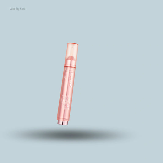A pink tube of Medicube Collagen Glow Booster Serum floats over a light blue background with a soft shadow beneath the tube.