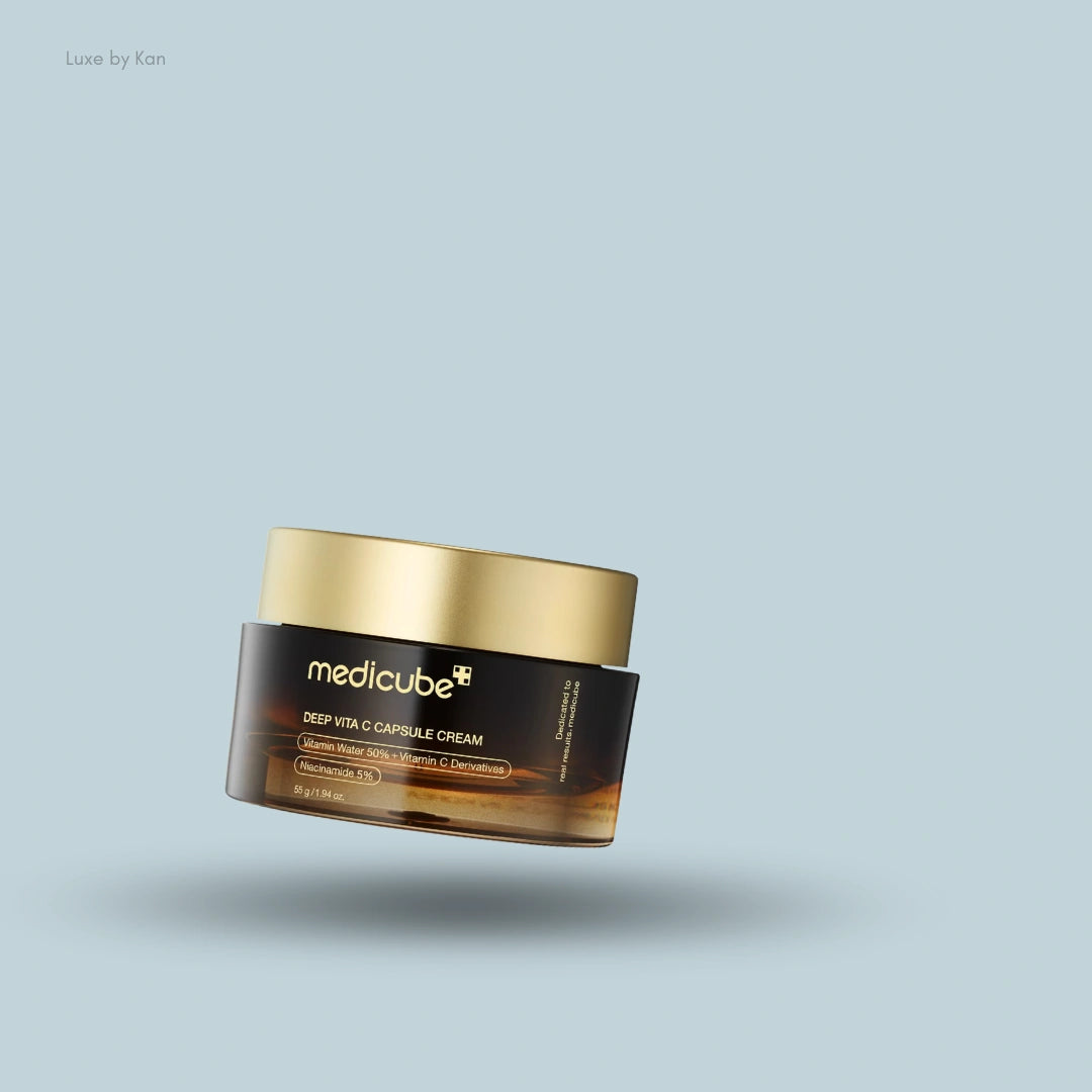 An amber jar of Medicube Deep Vita C Capsule Cream with a gold lid floats over a light blue background with a soft shadow.