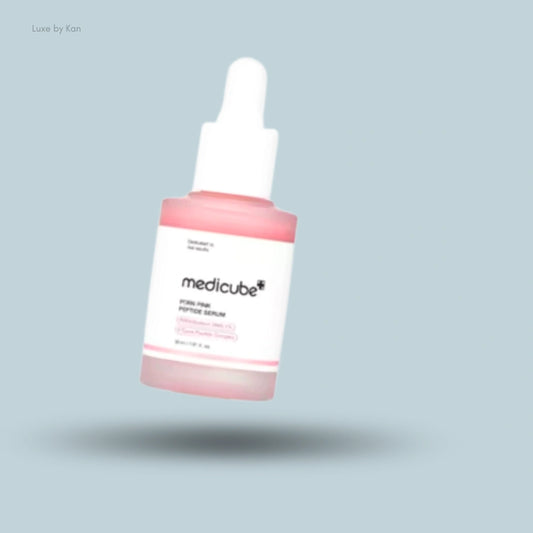 A sleek bottle of Medicube PDRN Pink Peptide Serum with a white dropper cap, set against a clean, light blue background.