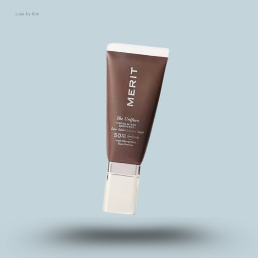 Merit Beauty The Uniform tinted mineral sunscreen SPF50 product in a dark brown tube with white cap and text.