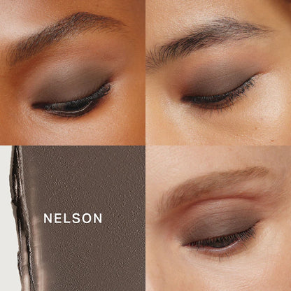Close-up of expertly shaped eyebrows and eye makeup, showcasing shades of brown with a blurred section of a product label at the bottom.
