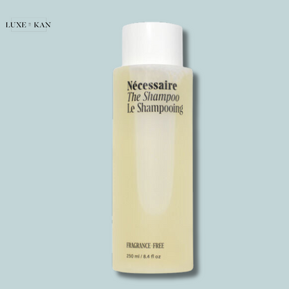 Nécessaire The Shampoo is a fragrance-free shampoo in a minimalist white bottle with pale yellow liquid inside.