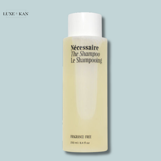 Nécessaire The Shampoo is a fragrance-free shampoo in a minimalist white bottle with pale yellow liquid inside.