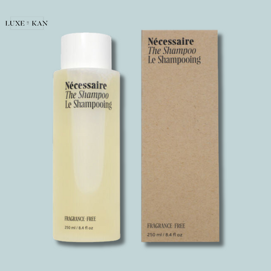 Nécessaire the Shampoo bottle next to its cardboard packaging both display branding and "Fragrance-Free, 250 ml/8.4 fl oz".