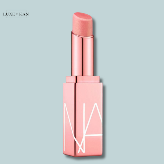 A soft pink nars afterglow lip balm in a sleek, modern tube with a minimalist design.