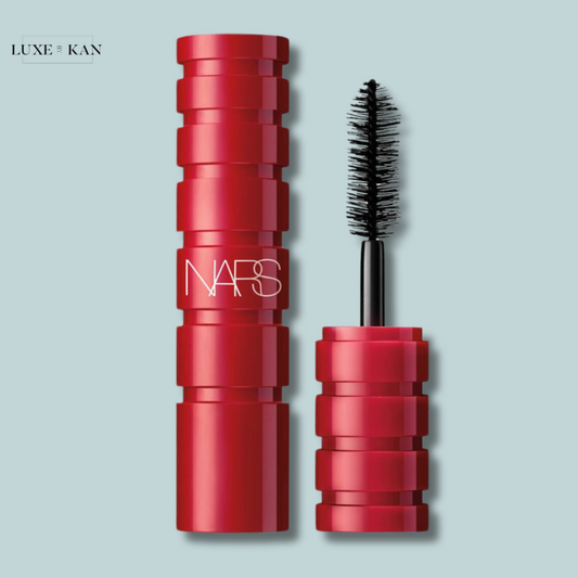 A bold red NARS climax mascara tube with a textured design, cap off, showcasing the brush next to the tube.